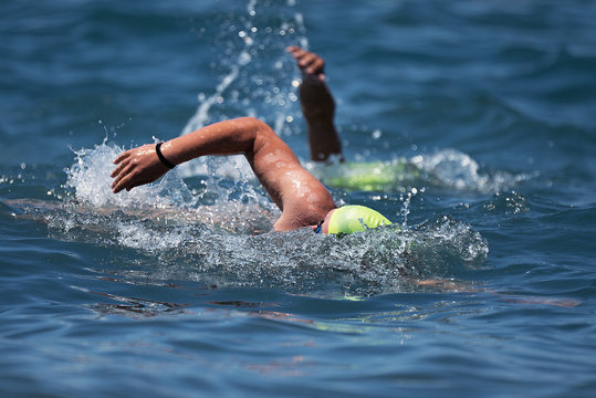 Swimmers swimming crawl in blue sea,training for triathlon
