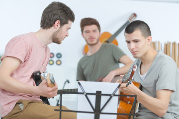 young men playing guitar and composing a song