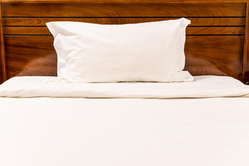 white pillow and blanket on wooden bed