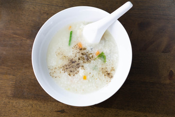 Closeup top view mush or boiled rice in white bowl, morning breakfast