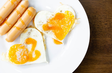Closeup Fried egg with sausage on white plate breakfast healthy food, selective focus