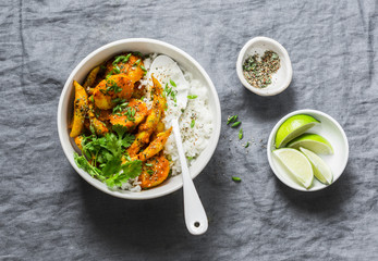 Potatoes and green beans curry with rice. Indian vegetarian healthy lunch on grey background, top view