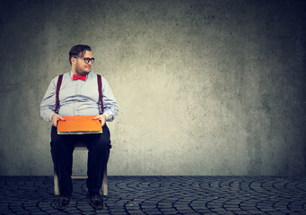 Business man with paper files sitting on chair
