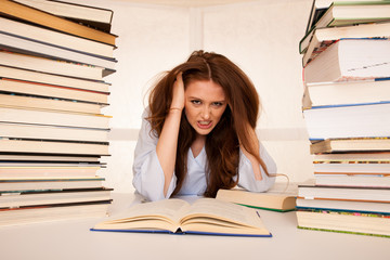 attractive young woman student undre stress while studiing for exames