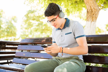 Teenage boy enjoying listening music with phone