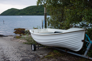 White rowing boat and trailer on slipway by the sea