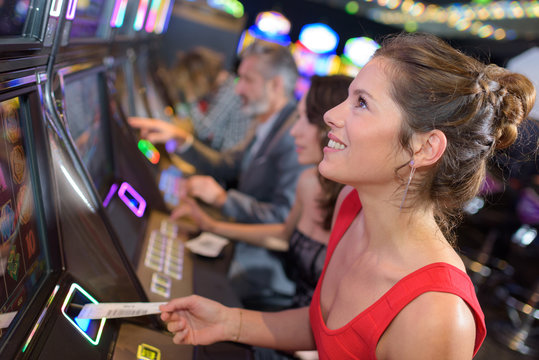 young beautiful woman playing the slot machine