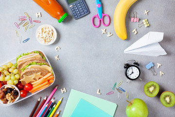 Back to school concept. Healthy lunch box and colorful stationery on table top view.