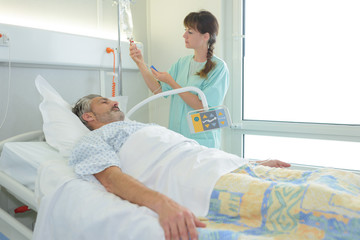 Obraz premium Nurse checking patient's drip