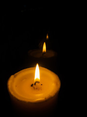 Candles Burning at Night. White Candles Burning in the Dark with focus on single candle in foreground.