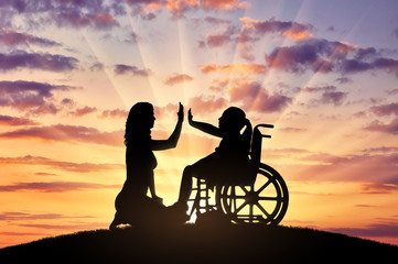 Happy disabled child girl in wheelchair and her mom on a walk