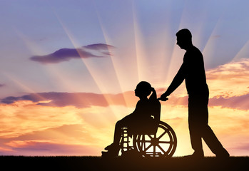 A disabled girl in a wheelchair and her dad on a walk