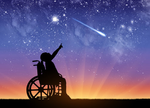 A disabled girl in a wheelchair against the starry sky