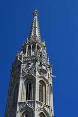 Fototapeta na wymiar Detail of highest gothic tower of Matthias Church in Budapest, Castle District, during summer season, clear blue skies. 