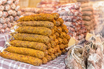 Dried organic salami sausage covered with spices on the market