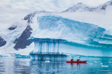 Poster winter kayaking in Antarctica, extreme sport adventure, people paddling on kayak near iceberg © Song_about_summer