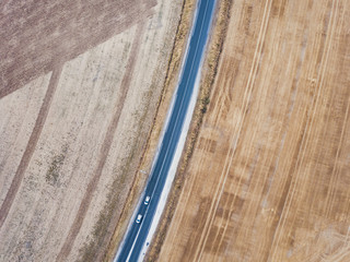 aerial view of asphalt road from drone, top down of two cars driving, geometry landscape