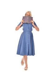 full length portrait of blonde girl wearing blue dress. standing pose holding a book. isolated on white  studio background.