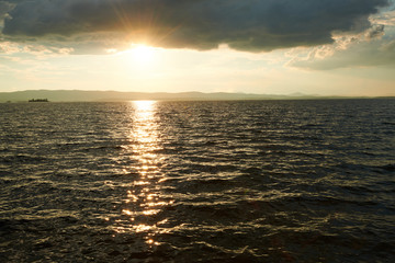 Beautiful sunset on the lake with cloudy sky