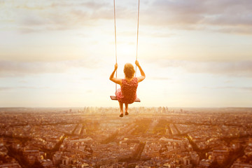 happiness and freedom concept, happy romantic beautiful young girl on the swing above the city...