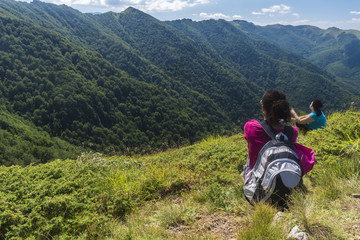 Naklejka na ściany i meble Beautiful girl in the mountains. An incredible view of the Troyan Balkan. The mountain captivates with its beauty, fresh air, a sense of infinity, coziness and tranquility.