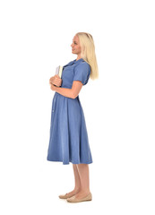 full length portrait of blonde girl wearing blue dress. standing pose holding a book. isolated on white  studio background.