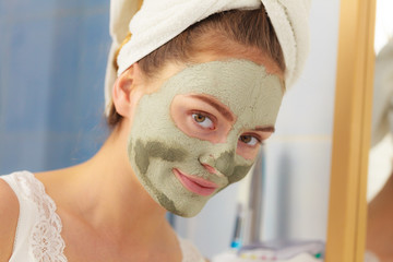Woman face with green clay mud mask