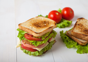 sandwich, tomato, toast, salad  on white wooden background