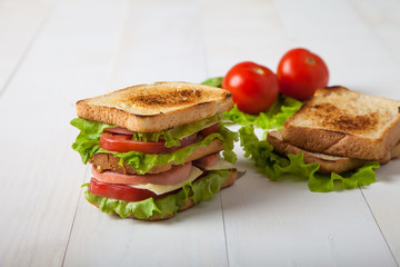 sandwich, tomato, toast, salad  on white wooden background