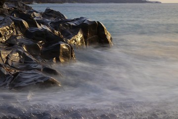 Glattgespülte Felsen am Ozean langzeitbelichtet 