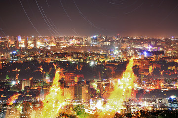 Fototapeta premium Urban night cityscape abstract collage with star tracks
