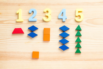 The child is studying the numbers and the account. Arranges the colored blocks to the desired numbers. Mathematics for children