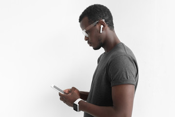 Closeup picture of handsome African American male standing isolated on gray background wearing...