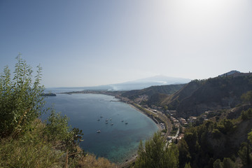 View from Taormina in Sicily of the Giardini Naxos bay and the Etna volcano in the background