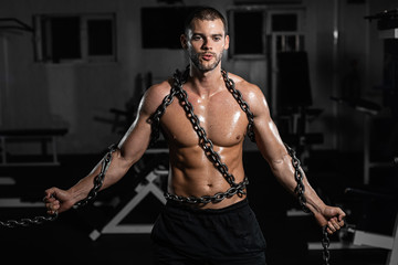 Muscular man slave in chains in gym, the prisoner