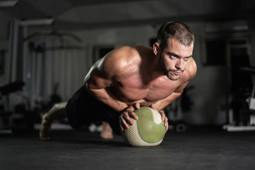 Naklejka premium Fitness man does push-ups on the ball
