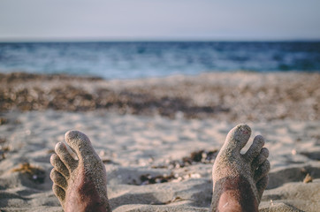 Sandy feet relaxing on the beach