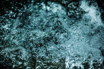 wild boiling water in a waterfall, dark blue with bubbles of air