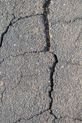 Cracked asphalt floor on a street in summer