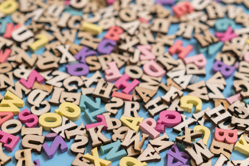 multicolored wooden letters of the English alphabet on a blue background.