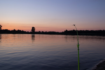 Evening feeder fishing on the river bank against the background of the sunset
