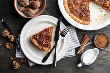 Traditional walnut pie with spices and nuts on dark wooden table, top view
