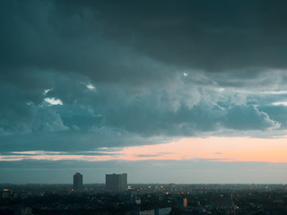Fototapeta na wymiar Cityscape of unknow city with thick clouds and sunset light.