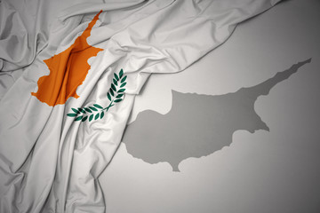 waving colorful national flag and map of cyprus.