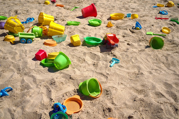 Beach toys in the sand. Abandoned plastic toys in empty playground with no children.