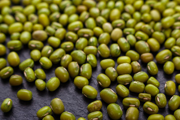 fresh Mung beans on a dark stone background