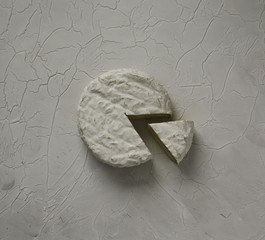 Ripe tasty cheese camembert or brie on a cracked table