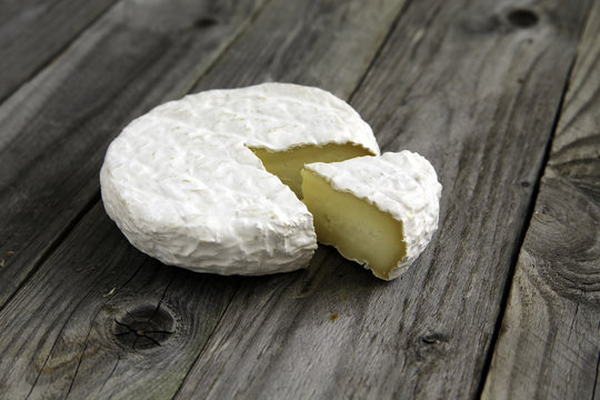 Ripe tasty cheese camembert or brie on an old plank table