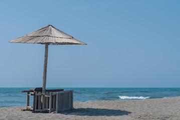 Fototapeta premium Panorama with sandy beach with wooden umbrellas and deck chairs