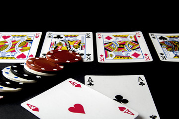 Poker, blackjack cards. Cards with chips in different situation isolated on black desk.